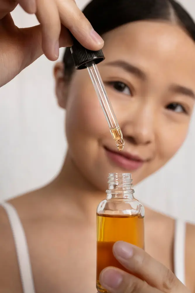 Une femme appliquant un sérum pour son layering coréen K-Beauty